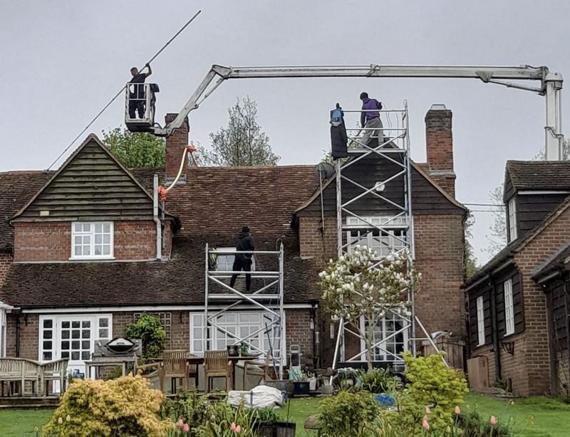 The Roof Moss Cleaners using cherry picker and scaffolding to clean roof safely and professionally in Bishop's Waltham, Hampshire